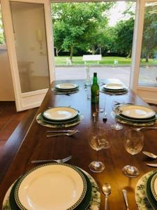 uma mesa com pratos e copos e uma garrafa de vinho em Disfruta de la naturaleza en el centro de Asturias em Siero