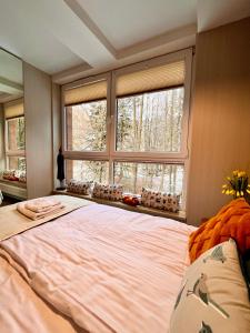 a large bed in a bedroom with a large window at Apartament SPA 04 Resort Kozubnik blisko Szczyrk - 5D Apartamenty in Porąbka