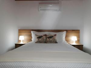 a bedroom with a bed with two pillows on it at A Casa da Formosinha in Madalena