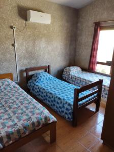 um quarto com duas camas e uma janela em Casa Palazzo em Barra del Chuy
