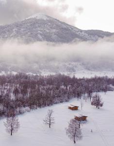 una cabaña en la nieve frente a una montaña en Vikendice Gornja Brezna - Mountain cabin Gornja Brezna, en Plužine