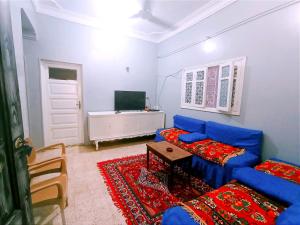 a living room with a blue couch and a table at Winji Guest house in Aswan