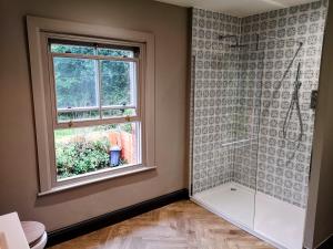 a bathroom with a shower and a window at Stunning New Forest Cottage close to Paultons Park in Ower