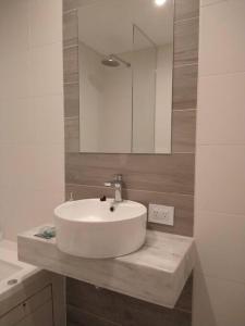 y baño con lavabo blanco y espejo. en Hermoso departamento zona Guemes en Mar del Plata