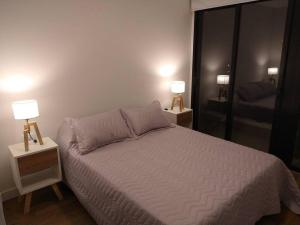 1 dormitorio con 1 cama y 2 lámparas en las mesas en Hermoso departamento zona Guemes en Mar del Plata