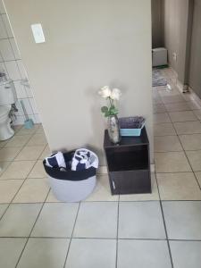 La salle de bains est pourvue de toilettes et d'un vase de fleurs. dans l'établissement The Westpoint -Modern ,secure apartment, à Roodepoort