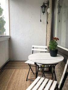 a table and two chairs on a porch with a potted plant at Lovely two room unit with free parking in Kuopio