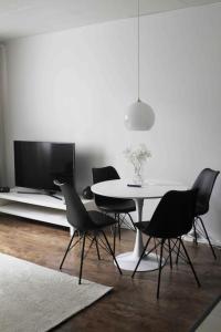a dining room with a table and chairs and a tv at Lovely two room unit with free parking in Kuopio