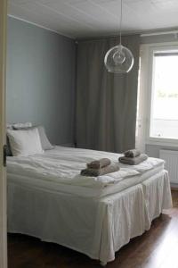 a bedroom with a white bed with two towels on it at Lovely two room unit with free parking in Kuopio