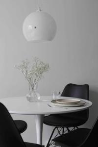 a white table with two chairs and a vase of flowers at Lovely two room unit with free parking in Kuopio