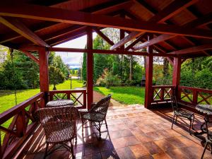 een patio met stoelen en tafels op een houten terras bij Sielsko i Zacisznie in Ełk