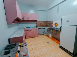 a kitchen with pink cabinets and a white refrigerator at Winji Guest house in Aswan