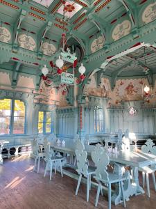 a dining room with white chairs and tables and a ceiling at Apartman Eden in Rožnov pod Radhoštěm