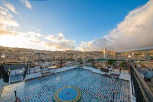 uma varanda com cadeiras e uma piscina num edifício em Riad Fes Elite em Fez