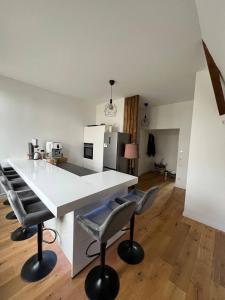 a kitchen with a white counter and some chairs at Wohnen wie im Schloss - Alter Bahnhof von Kruft in Kruft