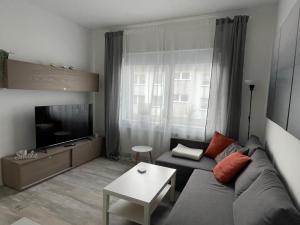 - un salon avec un canapé et une télévision dans l'établissement Heimathafen Wanne, à Herne