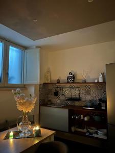 una cocina con un jarrón de flores sobre una mesa en Al centro exclusive apartment, en Brindisi