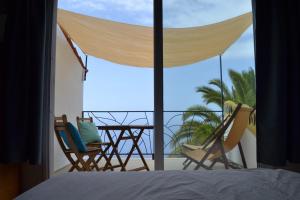 una camera da letto con vista su un balcone con sedie di El Quinto Pino apartamento con zonas comunes compartidas a Las Indias