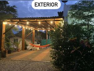 a patio with a hammock under a pergola with lights at Estancias De Olon in Olón