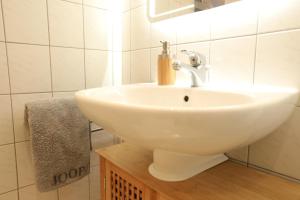 a bathroom with a white sink and a towel at Elbsandstein-Suite direkt im Stadtzentrum in Pirna +23 photos