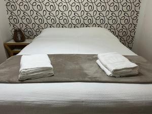 Una cama con dos toallas encima. en Cálido y Amplio Apartamento en Belgrano en Buenos Aires