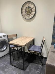 une table et une chaise avec une horloge sur le mur dans l'établissement Studi'o Lubéron, à Cavaillon