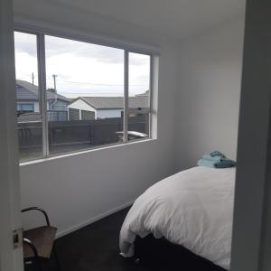 a bedroom with a bed and a large window at Riverton Cottage 2 Bedroom Close to beach in Riverton