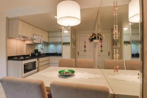 cocina y comedor con mesa y sillas en Conforto perto do centro, en Gramado