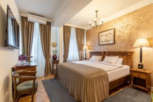a hotel room with a bed and a chandelier at Clucerului Arc De Triomphe in Bucharest