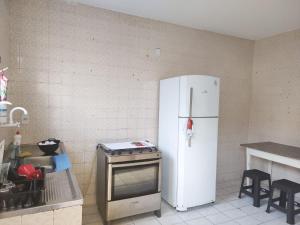 uma cozinha com um frigorífico branco e um fogão em Maré Hostel Itapuã em Salvador