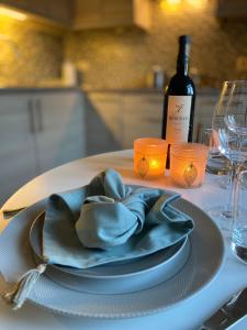 un plato con una servilleta en una mesa con una botella de vino en Vakantiestudio Ouanaïo, en Zedelgem