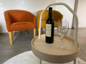 een fles wijn en een glas op een tafel bij Vakantiestudio Ouanaïo in Zedelgem