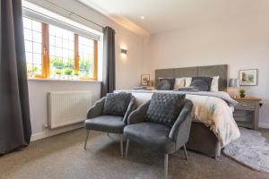 a bedroom with a large bed and two chairs at Wick House in Taunton
