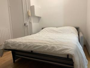 ein unmaskiertes Bett in einem kleinen Zimmer mit weißer Bettwäsche in der Unterkunft Chambre à Saint-Mandé entièrement refait à neuf in Saint-Mandé