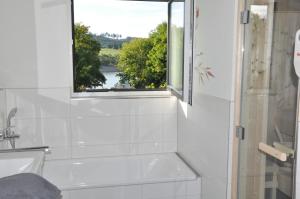 a bathroom with a bath tub and a window at Ferienhaus direkt am Diemelsee-Heringhausen-Willingen-Toplage-Sauna-3 Schlafzimmer-2 Terrassen-109 qm-incl Wäsche in Diemelsee +32 photos