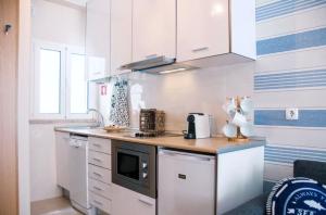 a kitchen with white cabinets and a counter top at Portuguese Wonders in Nazaré +20 photos