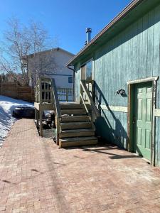 un edificio verde con una escalera junto a una puerta en Cozy Mountain Home Close To Hiking, Ski &Red Rocks, en Kittredge