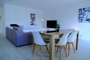 a dining room with a table and white chairs at CALYPSO- Grand T3 - Arrivée Autonome - Parking & Wifi gratuit in Melun