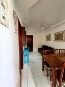 a living room with a table and a couch at Apartamento Ubatuba 150m do mar Maranduba in Ubatuba