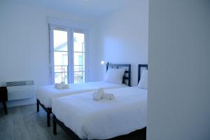 two beds in a room with blue lighting at CALYPSO- Grand T3 - Arrivée Autonome - Parking & Wifi gratuit in Melun