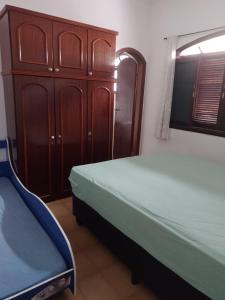 a bedroom with a bed and a cabinet and a bed at Casa de Praia em Praia Grande (SP) in Solemar
