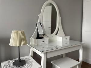 a white dressing table with a mirror and a lamp at Koza Apartment, next to Akbati Shopping Mall and Tennis court Soul Entertainment in Istanbul