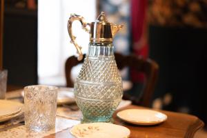 a table with a glass water pitcher on a table at Au Gentleman Cambrioleur in Charleville-Mézières