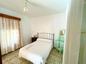 1 dormitorio con cama blanca y mesa en Casa Béjar, Tranquila casa con chimenea, patios, junto a la piscina, en Cañete la Real