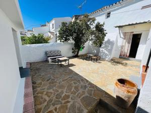 un patio con un banco y una mesa en un edificio en Casa Béjar, Tranquila casa con chimenea, patios, junto a la piscina, en Cañete la Real