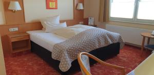 ein Hotelzimmer mit einem Bett mit einer Decke darauf in der Unterkunft Sonnenhof in Lügde