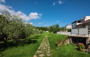 un jardin avec des arbres et un chemin en pierre dans l'établissement Istrian Tavern next to the Pool, à Banjole