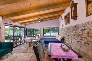 a living room with a couch and a stone fireplace at Istrian Tavern next to the Pool in Banjole