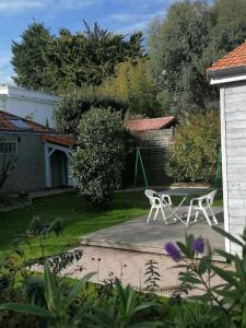 d'une terrasse avec 2 chaises et une table dans la cour. dans l'établissement le chalet de laura, à Pornic