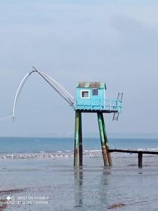 une tour de sauveteur sur la plage avec l'océan dans l'établissement le chalet de laura, à Pornic